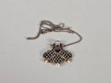 a close up of a necklace on a white surface with a chain