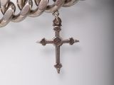 a silver chain with a silver cross on it
