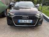 a black audi parked in a parking lot next to a car