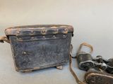 an old suitcase with a pair of binoculars next to it