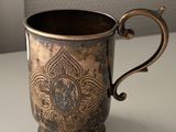 a silver cup sitting on a white table next to a window