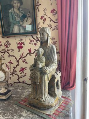 a statue of a woman sitting on a chair next to a clock