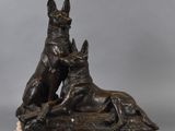 a bronze statue of two dogs and a cat on a marble base