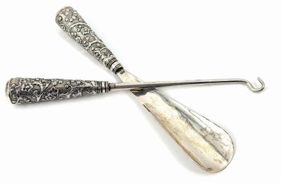 two silver spoons and a spoon rest on a white surface