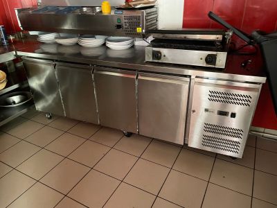 une cuisine équipée d'appareils électroménagers en inox et aux murs rouges