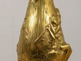 a gold vase sitting on top of a wooden table