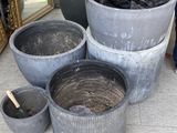 many pots that are sitting on the ground next to each other