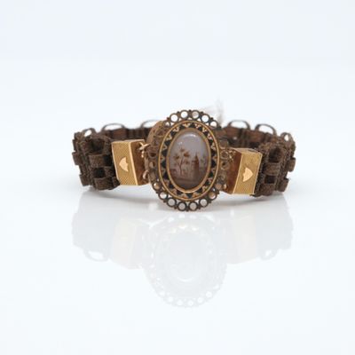 un bracelet marron sur lequel est représentée une femme