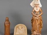 three carved figurines of a woman and a statue of a man