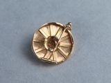 a gold plated brooch with a clock on it