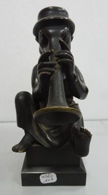 a statue of a man sitting on a stool playing a flute