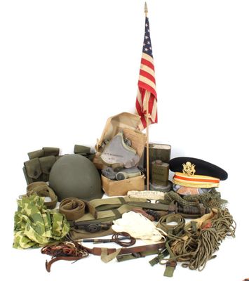 a pile of military items on a table with an american flag in the background