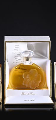 two bottles of perfume sitting in a box on top of a table