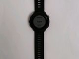 a close up of a black watch on a white surface