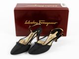 a pair of women ' s black shoes in front of a box