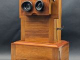 un vieux téléphone en bois surmonté de deux jumelles