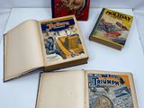 trois livres sont posés sur une table à côté d'une boîte remplie de livres