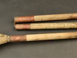 three wooden spoons with handles on a table with a gray background