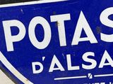 a blue and white sign with a picture of a building in the background