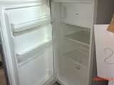 a white refrigerator with its door open and a person standing next to it