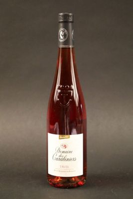 La bouteille de vin est posée sur la table, sur un fond noir.
