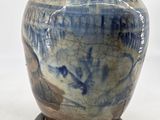 a blue and white vase with a light on it