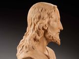 a carved bust of a man with long hair and a beard