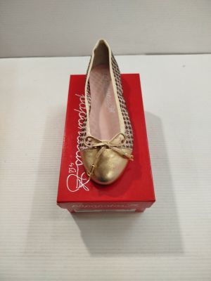 Quelqu'un porte une paire de chaussures dorées ornées d'un nœud.