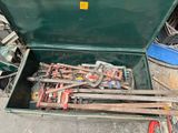une boîte verte posée par terre, contenant des outils