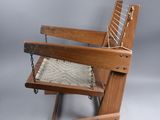 the chair is made of wood and has a woven seat