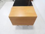 a small wooden table with a black top on a white floor