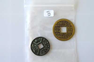two chinese coins sitting on top of a plastic bag