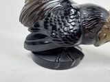 a figurine of a fish on a black base