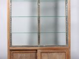 an image of a wooden display case with glass shelves and doors