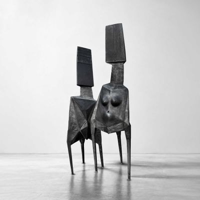 black and white photograph of a sculpture of a woman sitting on top of a chair