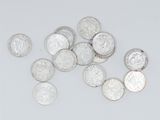 some silver coins are scattered on a white surface
