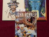 trois livres posés sur un tissu rouge