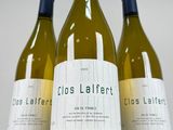 three bottles of white wine sitting on top of a white table