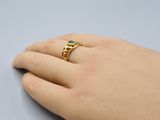 someone is holding a gold ring with a green stone on it