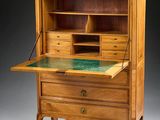 an old wooden desk with a glass top and drawers