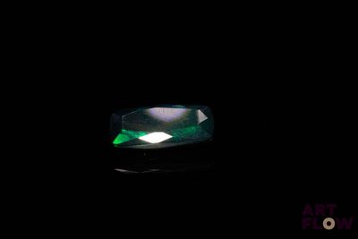 un gros plan d'une émeraude verte sur une surface noire