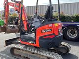 an image of a small excavator parked in a parking lot