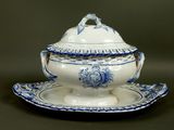 a blue and white tureeny with a lid on a plate