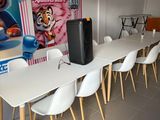 des tables et des chaises dans une pièce où est accrochée une grande affiche au mur