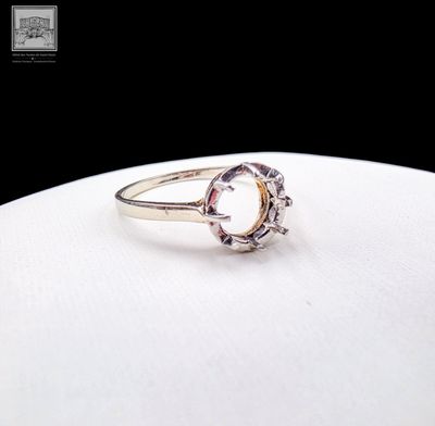 a close up of a ring on a white plate with a black background