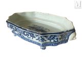 a blue and white bowl with a handle on a stand