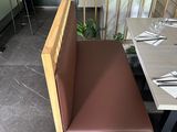 a wooden bench with a brown seat next to a wooden table
