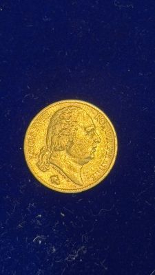 a close up of a gold coin on a blue surface