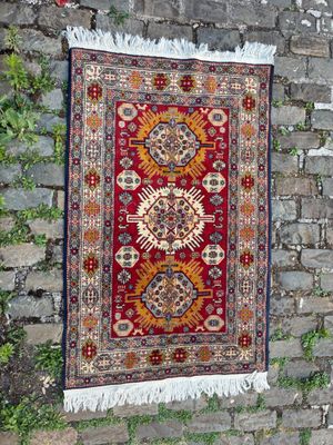 un tapis rouge accroché à un mur de briques, à côté d'un mur de briques