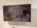 une télévision à écran plat fixée au mur au-dessus d'un bureau